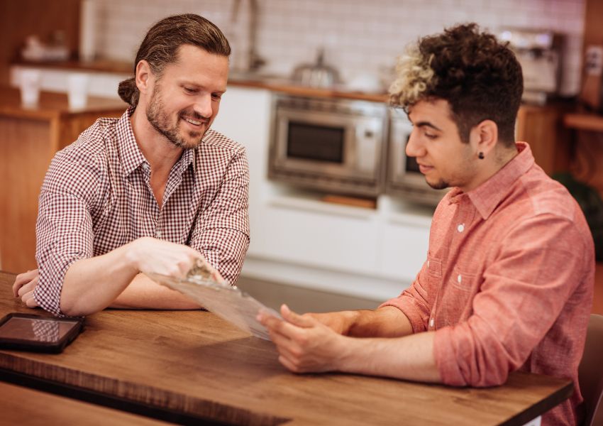 two-people-talking-over-papers