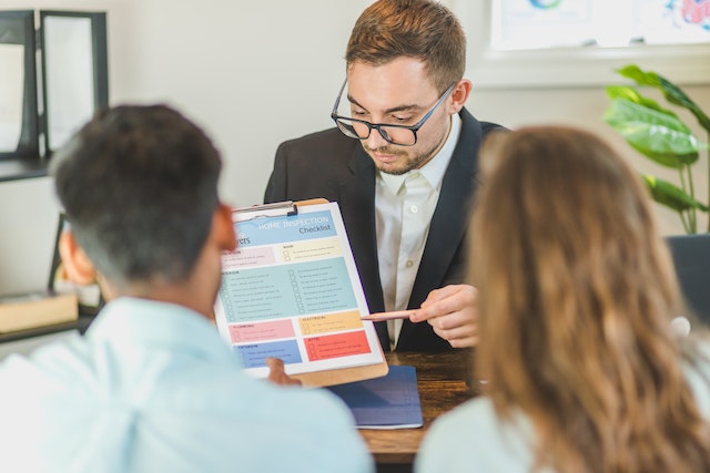 Property manager showing a document on a clipboard to two people