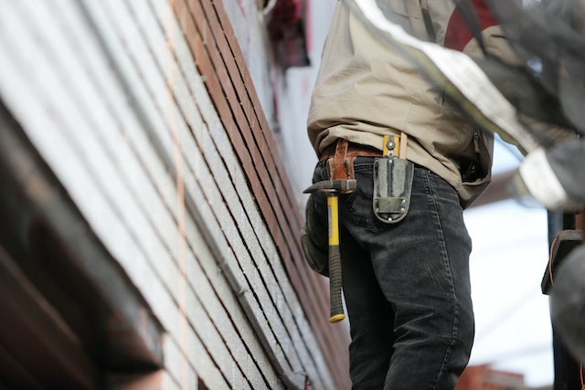 close up of a person's legs and torso next to the exterior of a rental property